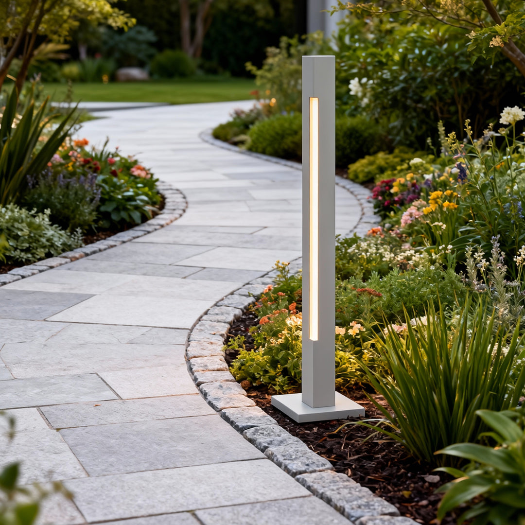 Garden path bordered by silver led bollard light fixtures providing warm illumination across landscaped curves.