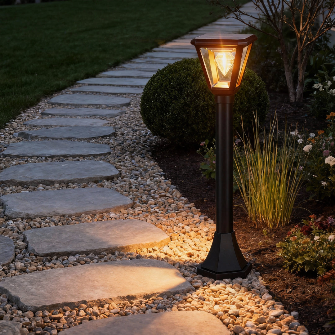 Warm-lit led post cap lights installed along a stone garden pathway, creating an inviting nighttime landscape.