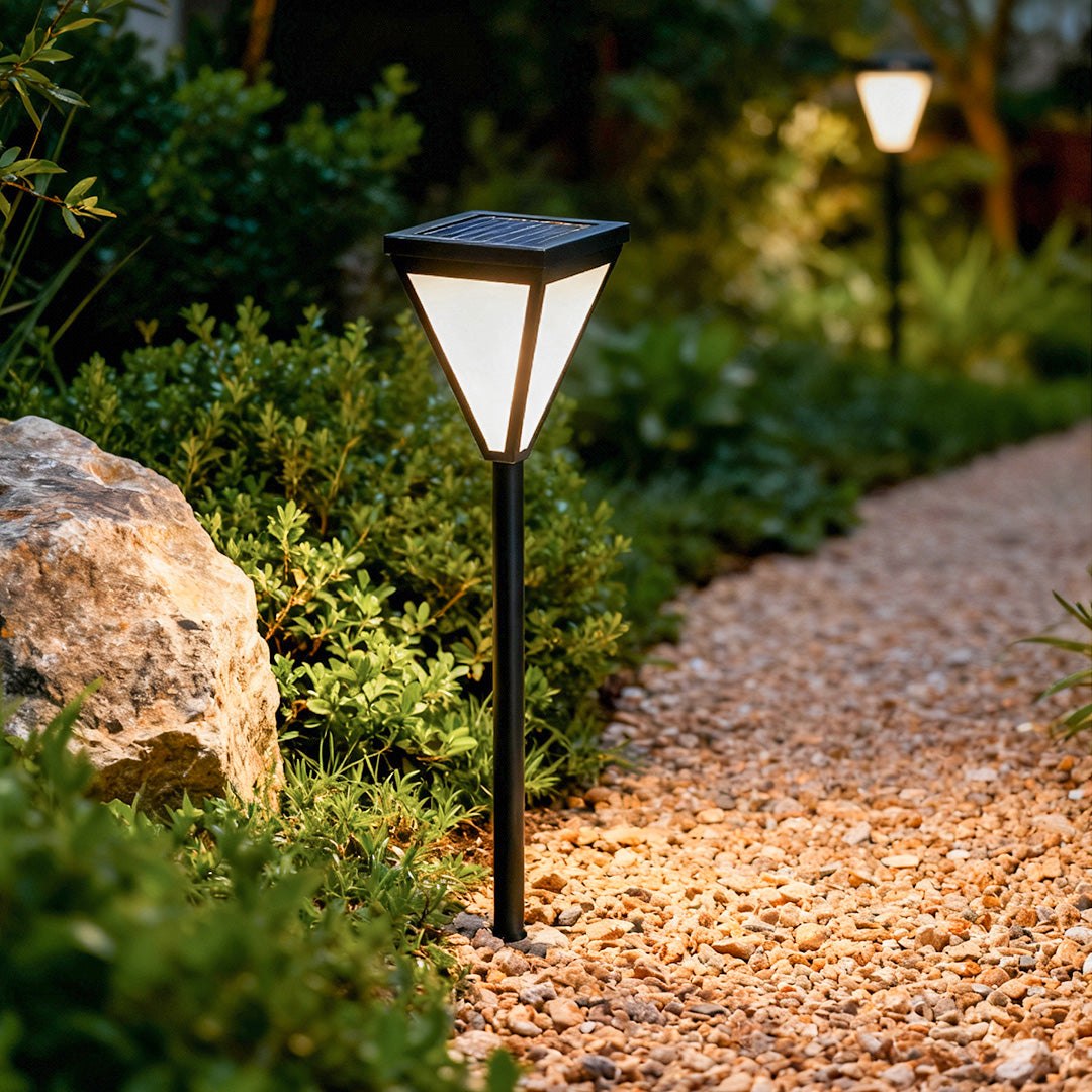 Outdoor solar lights wall mounted illuminating a garden pathway at dusk.
