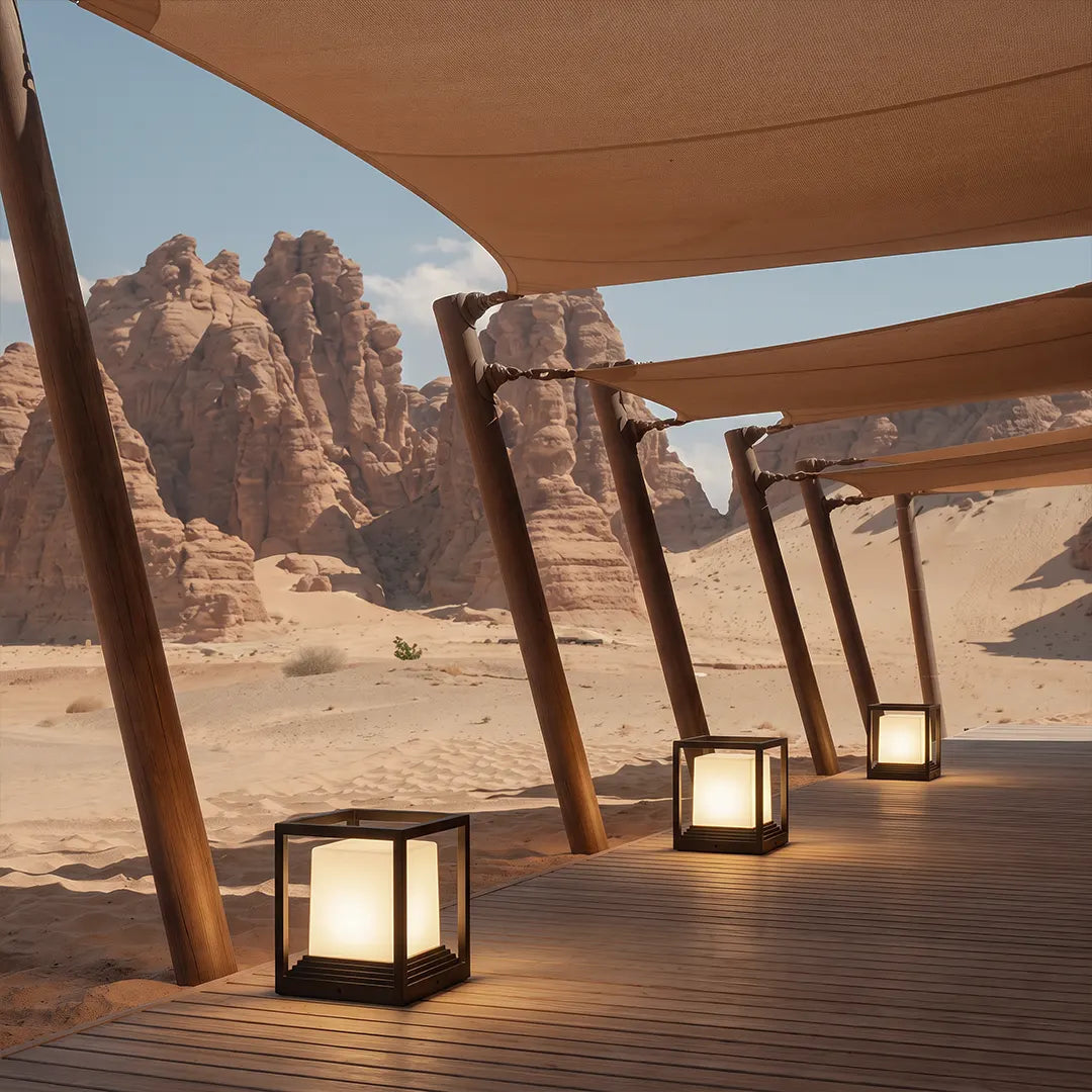 Garden pedestal lights in a minimalist cube style illuminating an outdoor deck in a desert landscape.