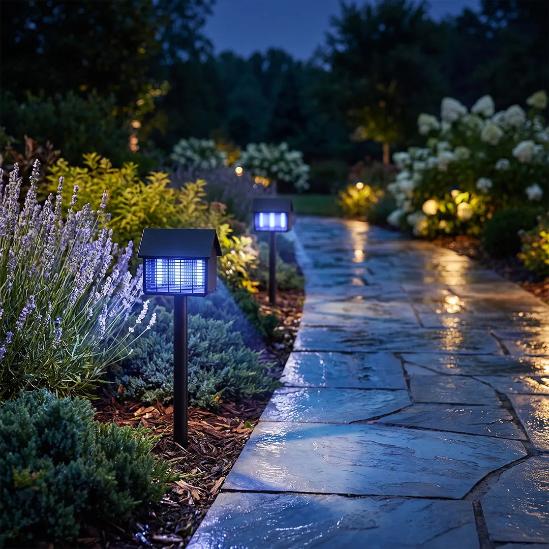 Garden solar path lights illuminating a wet stone walkway with cool blue light in a lush landscape.