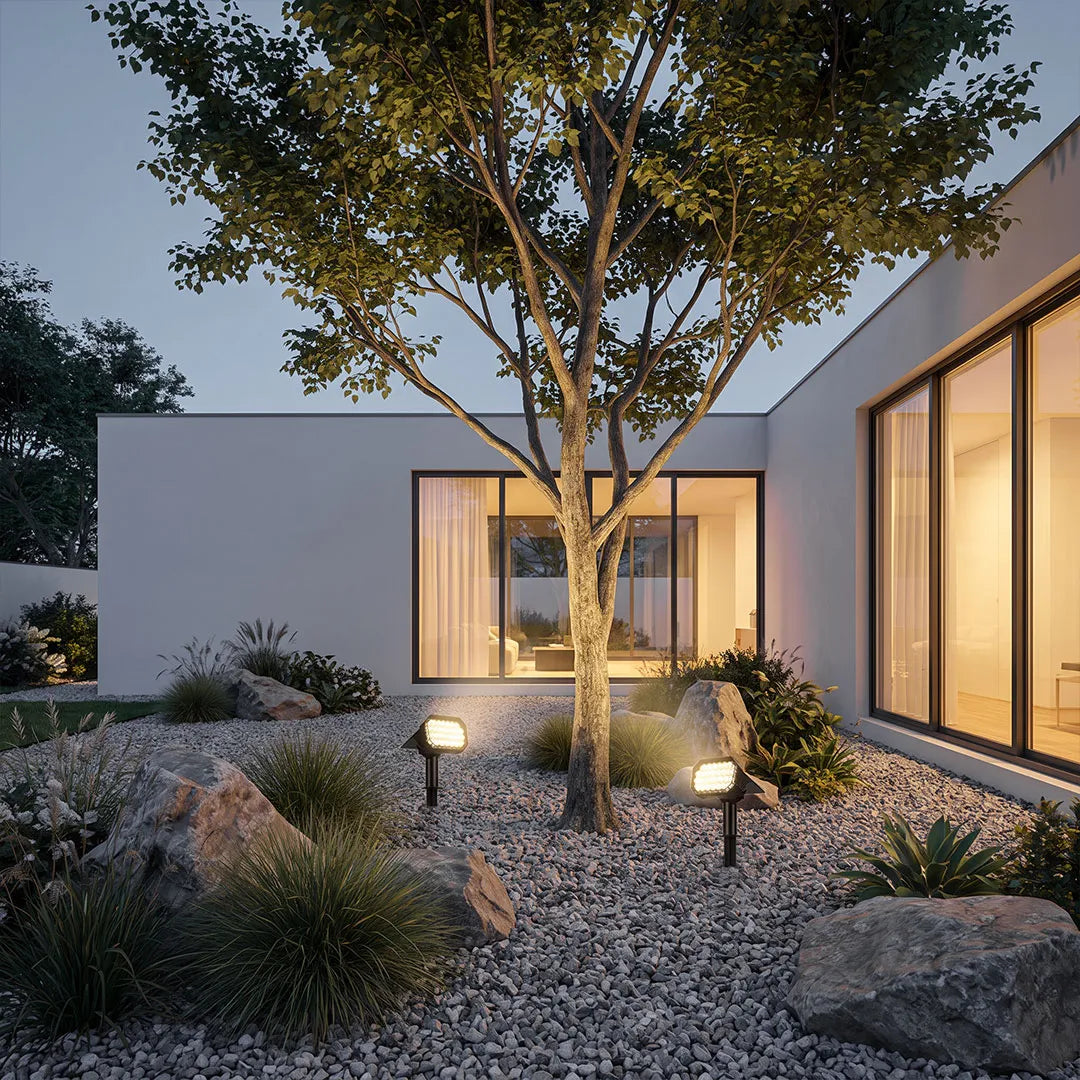Garden stake solar lights providing accent illumination throughout a landscaped courtyard garden.