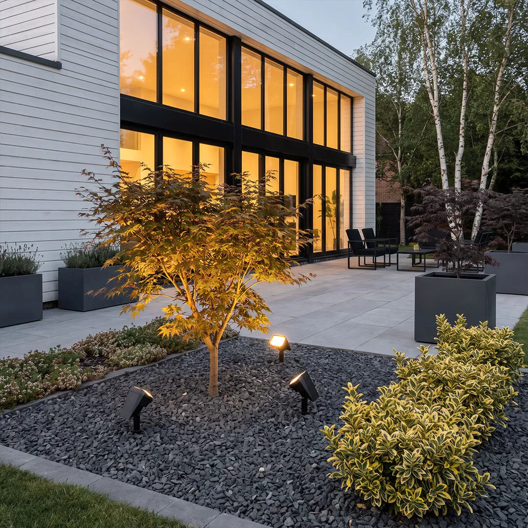 Garden stake solar lights installed in a modern residential landscape with warm accent lighting.