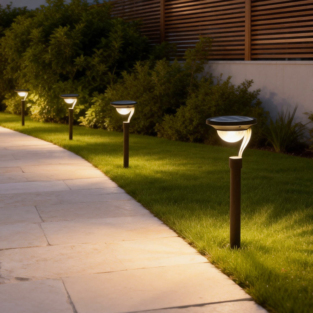 Garden stake solar lights illuminating a pathway with warm, soft light.