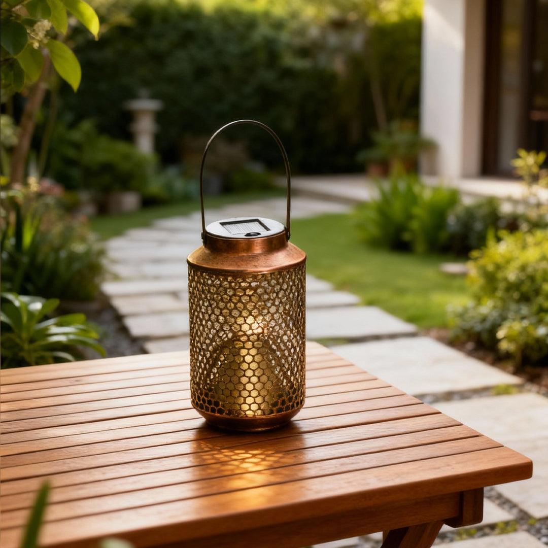 Portable solar lantern placed on an outdoor wooden table, glowing warmly in a garden.