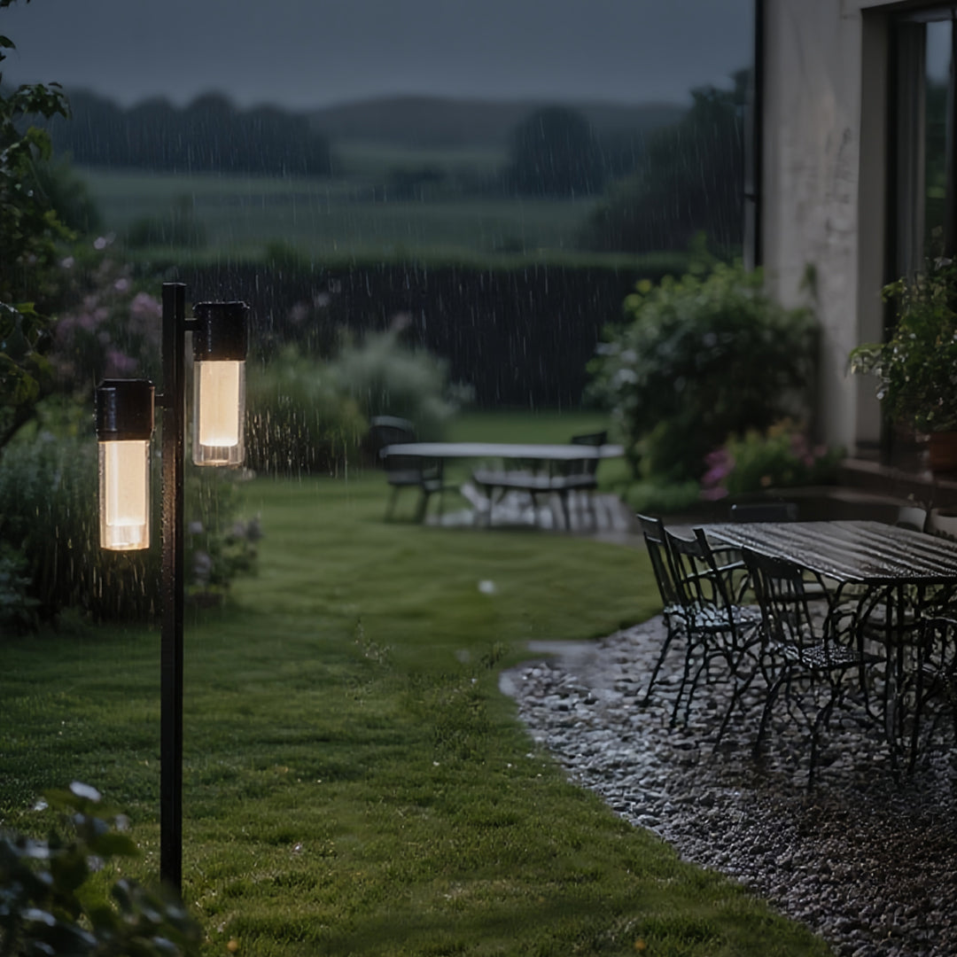 Modern outdoor garden scene with a contemporary path light mounted beside a rock-lined walkway.