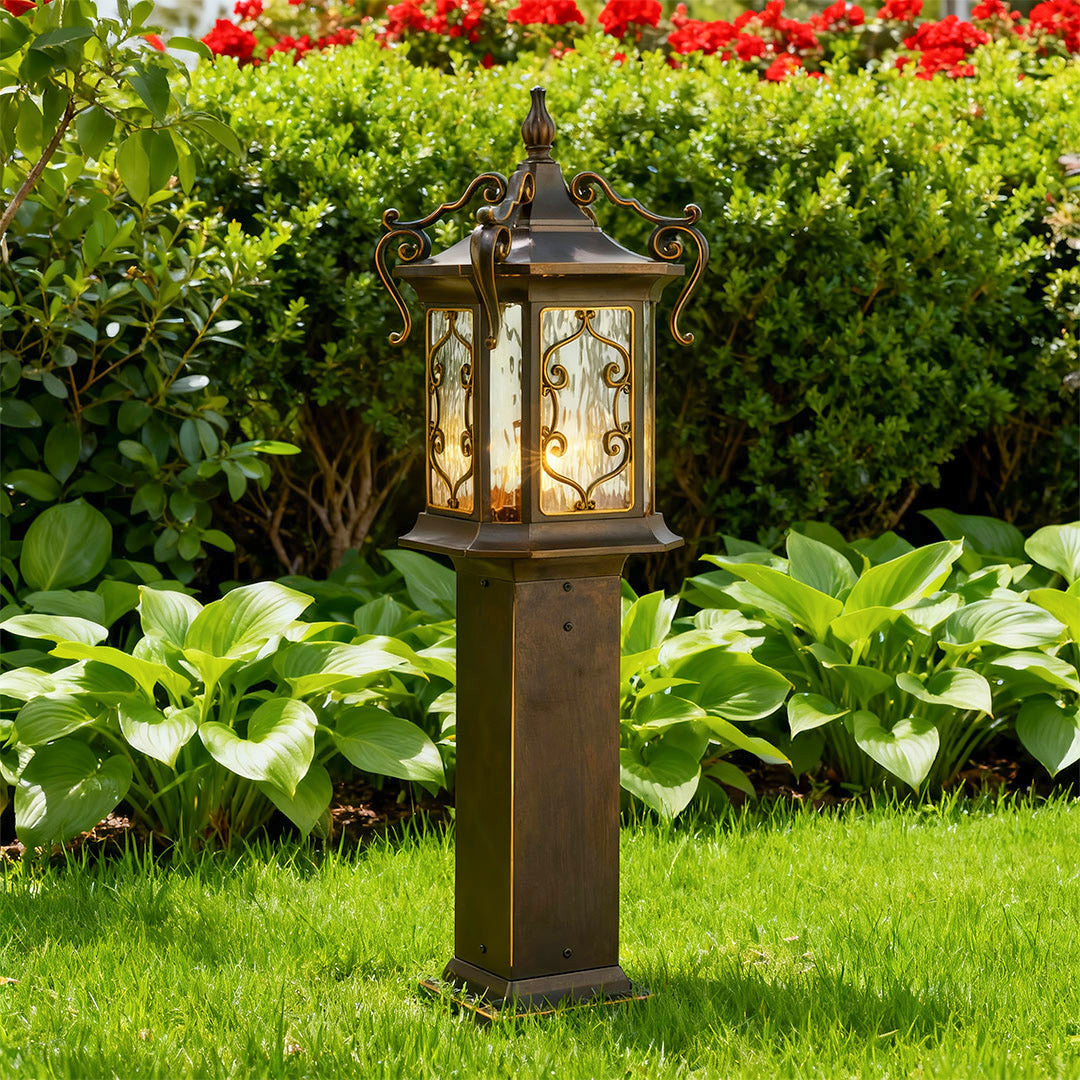 Landscape post lights illuminating garden walkway with warm yellow light at sunset.