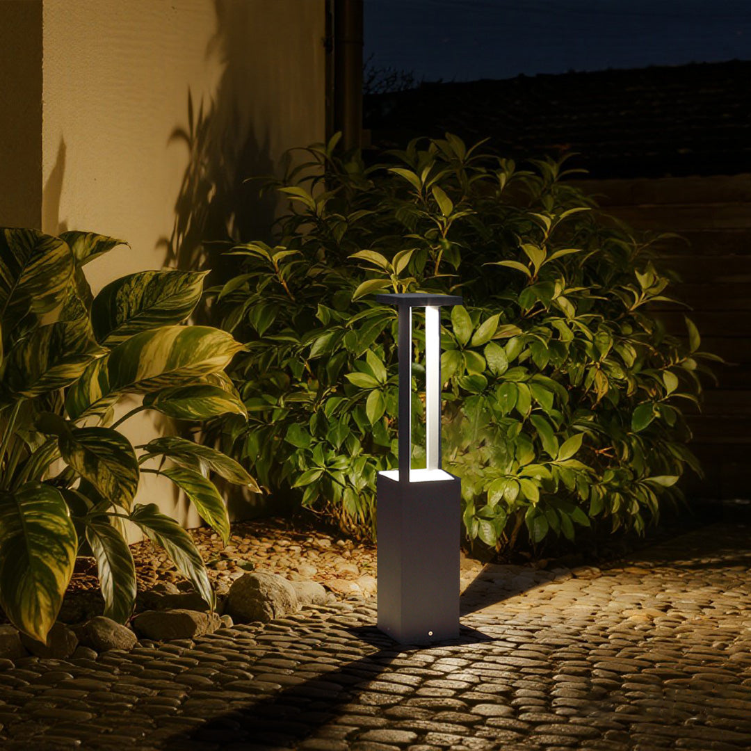 Warm LED bollard lights illuminating garden walkway with lush surrounding vegetation
