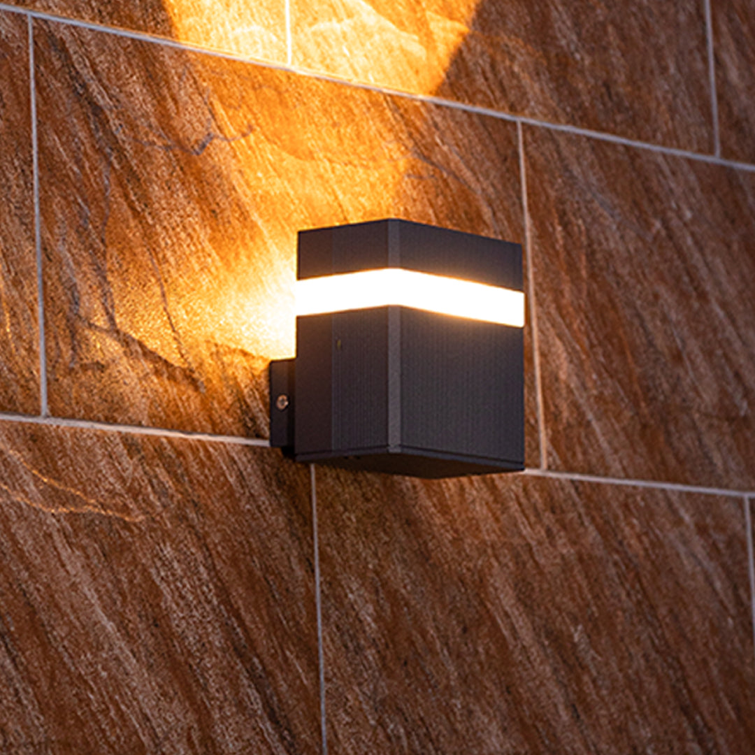 Garden wall light with dual beams illuminating wooden textured facade at night
