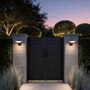 Garden wall lights illuminating a modern house entrance with warm directional glow.