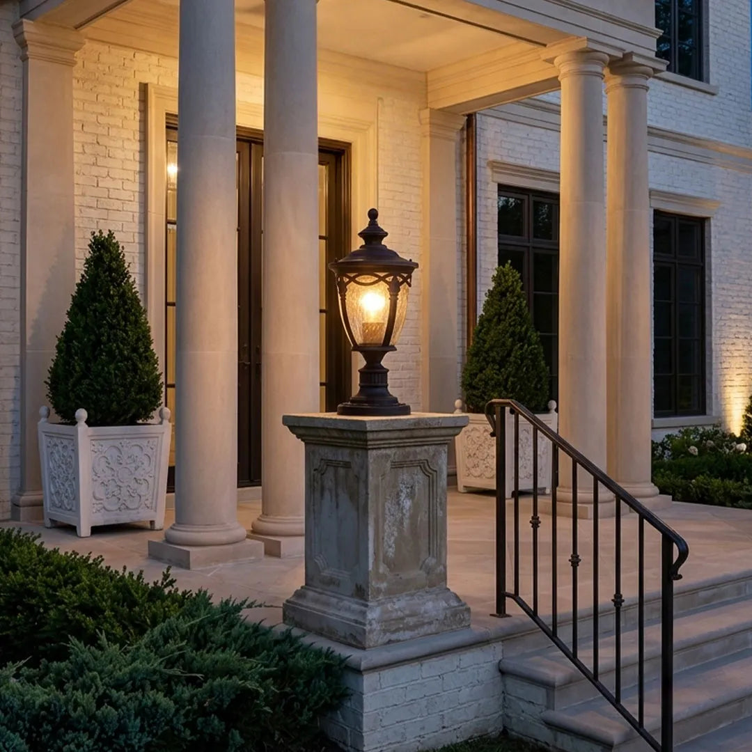 Gate pillar light displayed on a square pedestal beside front porch steps and white columns.