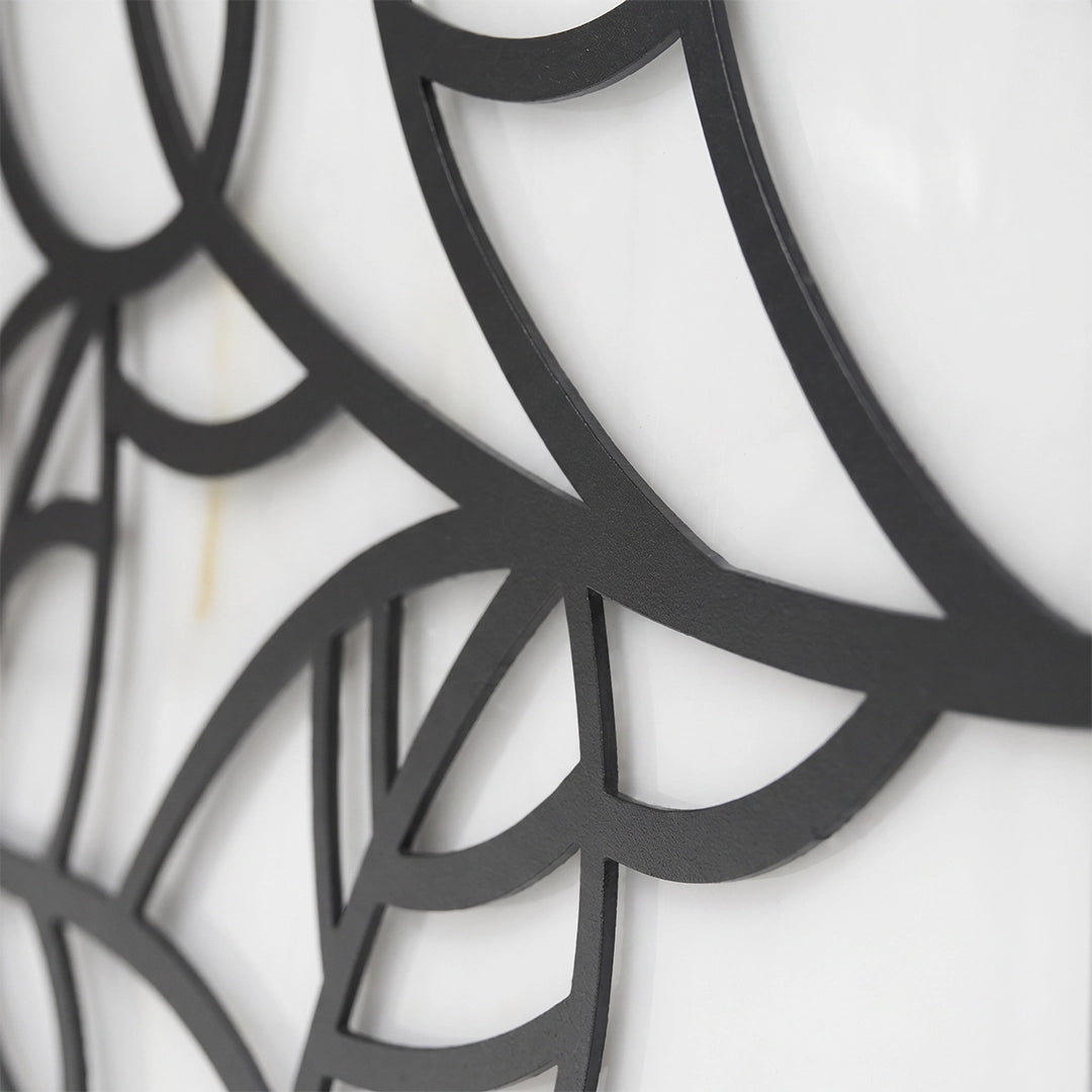 Close-up of the black leaf-pattern frame detail on a gate pillar light.