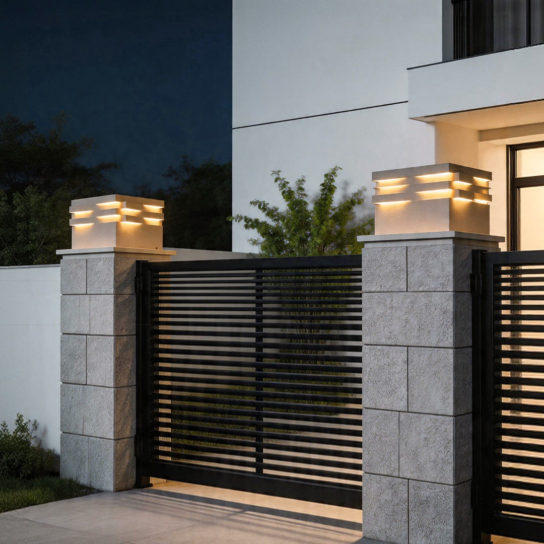 Gate post solar pillar light illuminating modern driveway gate with stylish layered LED design.