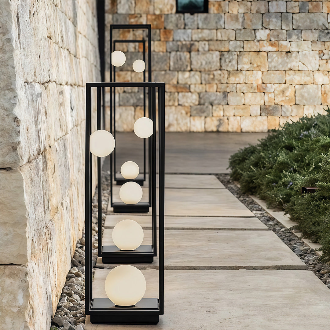 Close-up shot of a bollard outdoor light with a geometric frame and smooth glowing sphere, perfect for outdoor décor.