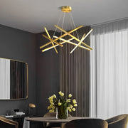 Geometric ceiling light with gold linear LED bars suspended in a modern living room, creating an artistic focal point and warm ambient glow.