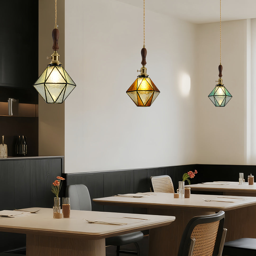 Geometric diamond-shaped pendant lights in modern restaurant setting with neutral decor and stylish dining chairs