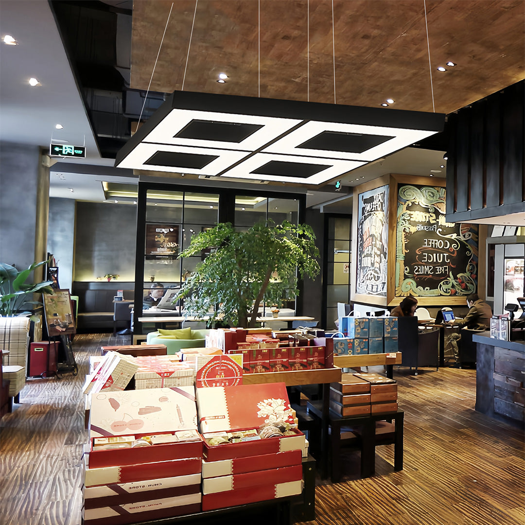 Geometric modern black chandelier installed in a vibrant commercial space, providing stylish and functional lighting.