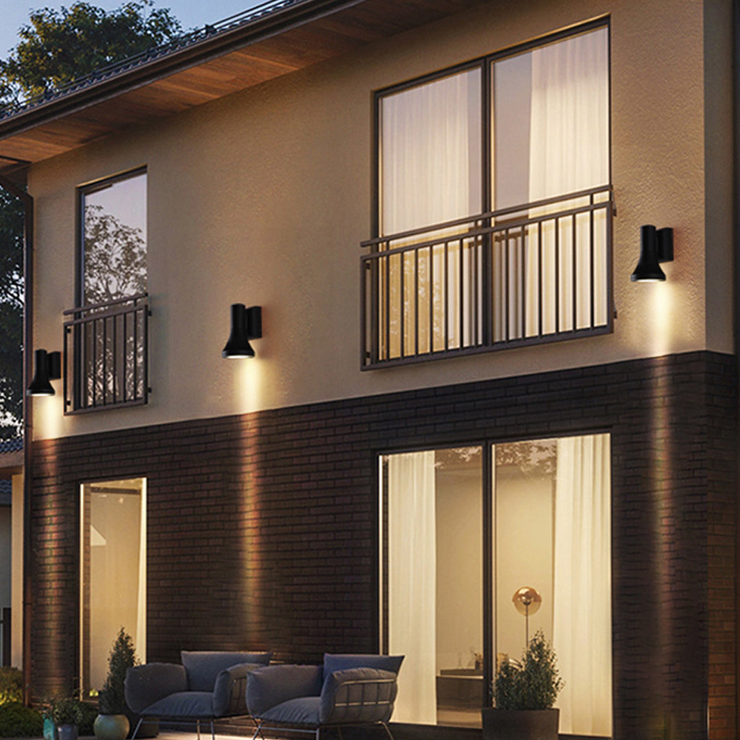 Contemporary two-story house with multiple geometric Outdoor Wall Lighting Fixtures accenting the patio and exterior facade.