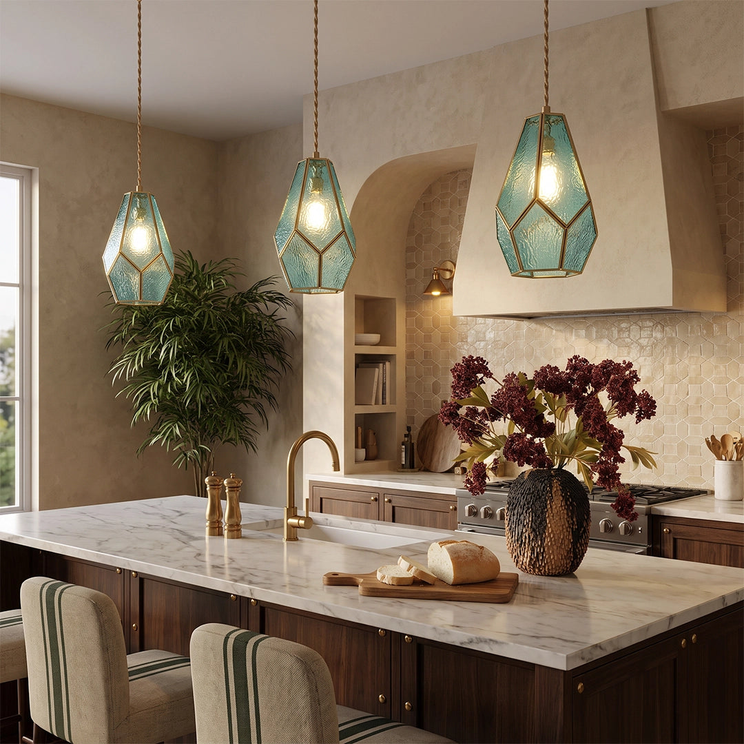 Geometric pendant lights above a kitchen island with warm lighting and a textured backdrop.