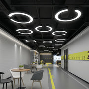 Geometric pendant lights arranged overhead in modern office corridor with yellow accent stripe