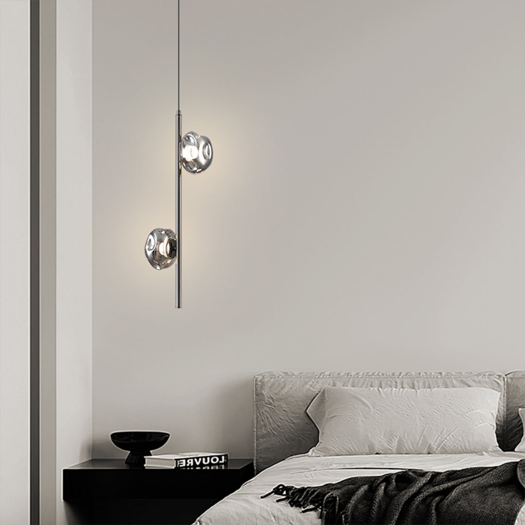 Modern vertical pendant light with geometric glass arrangement creating dramatic interior lighting