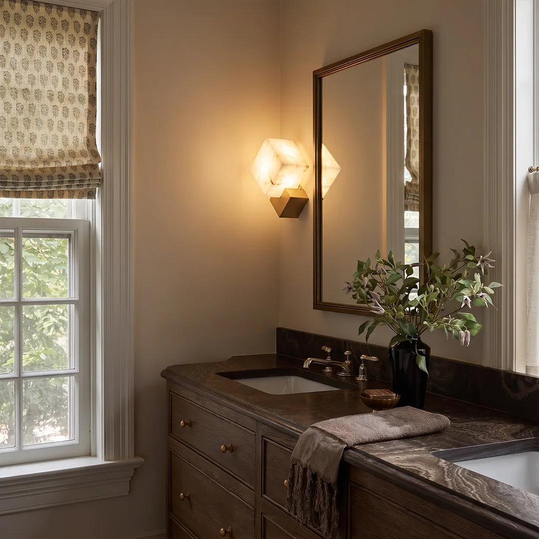 Geometric wall sconce mounted beside a mirror above a dark wood bathroom vanity.