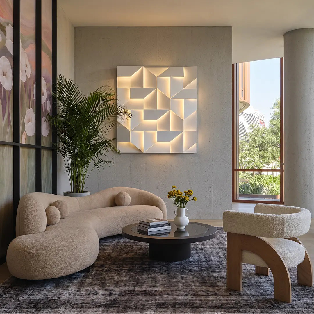 Geometric wall sconce light illuminating a contemporary lounge with sculptural furniture.