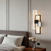 Geometric wall sconce light illuminating a modern bedroom with warm ambient glow.