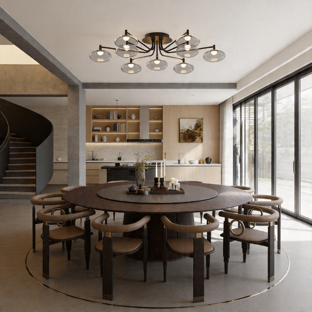 Contemporary glass ceiling light above a round dining table in an open-plan interior.