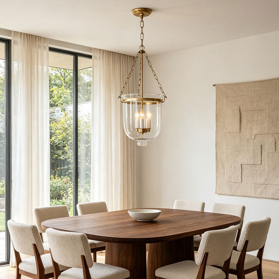 Glass chandeliers for dining room styled above a modern wooden dining table in a bright elegant interior.