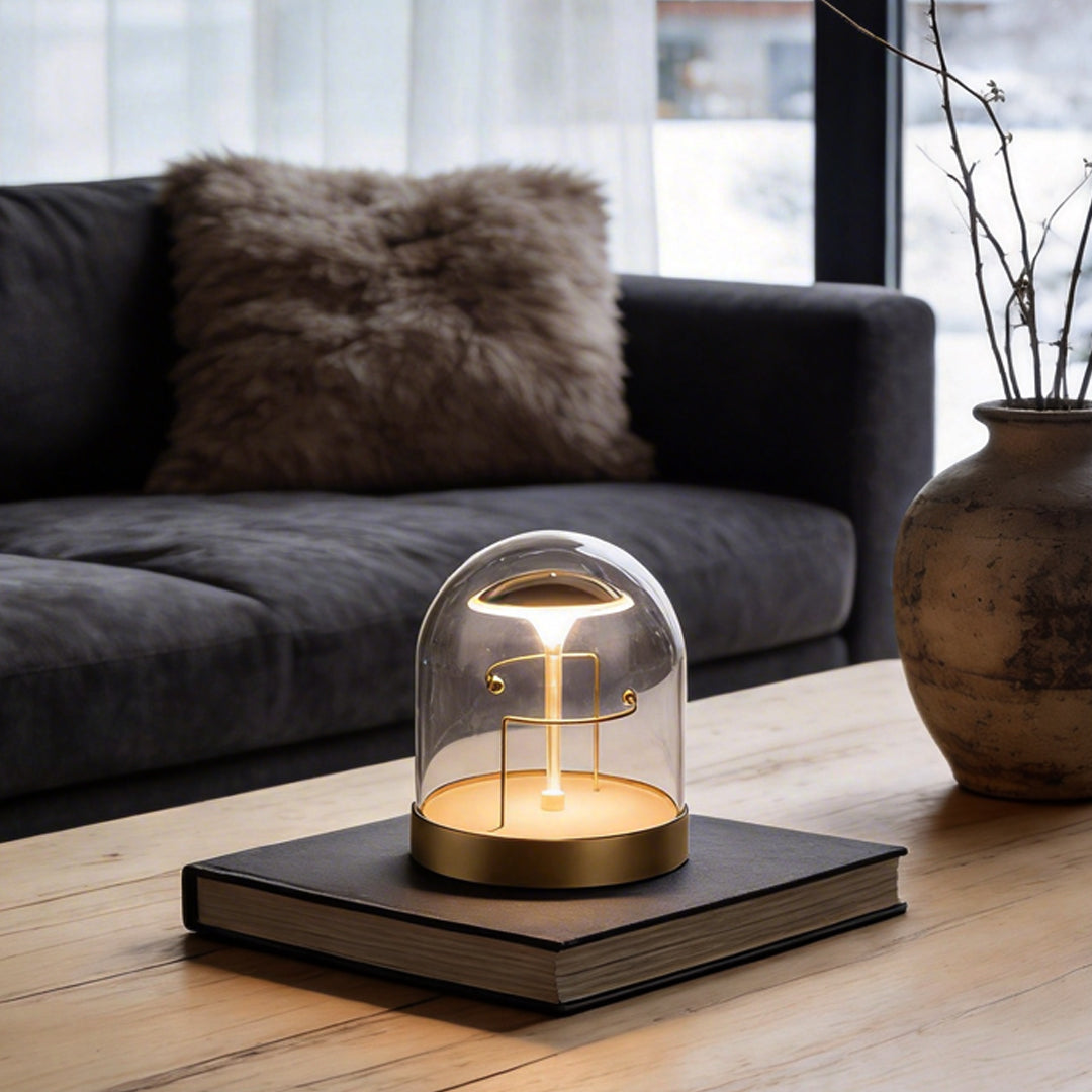 Glass dome LED lights with a gold base, providing warm illumination on a coffee table.