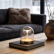 Glass dome LED lights with a gold base, providing warm illumination on a coffee table.