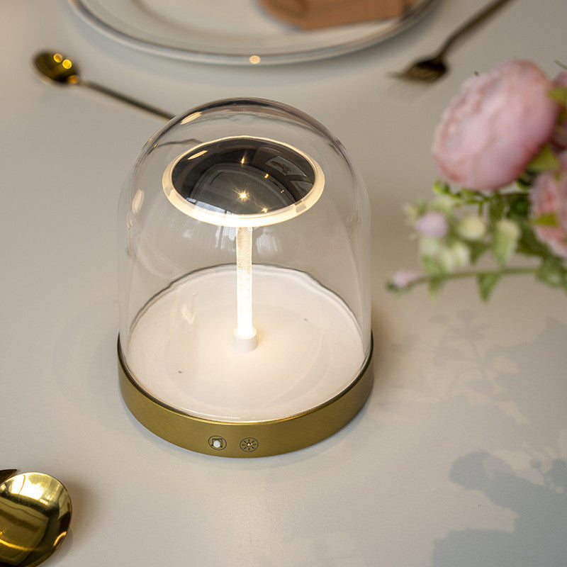 Glass dome LED lights with a gold base, illuminating a cozy dining table.