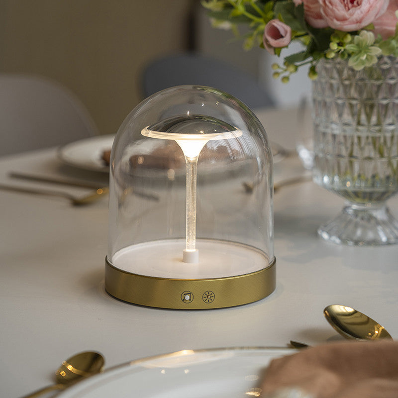 Glass dome LED lights with a gold finish, providing elegant lighting in a dining setting.
