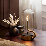 Glass dome table light illuminating a cozy living room corner with warm, ambient glow.