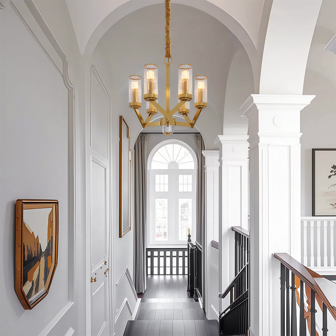 Glass drop chandelier illuminating elegant hallway with arched ceiling and classic decor