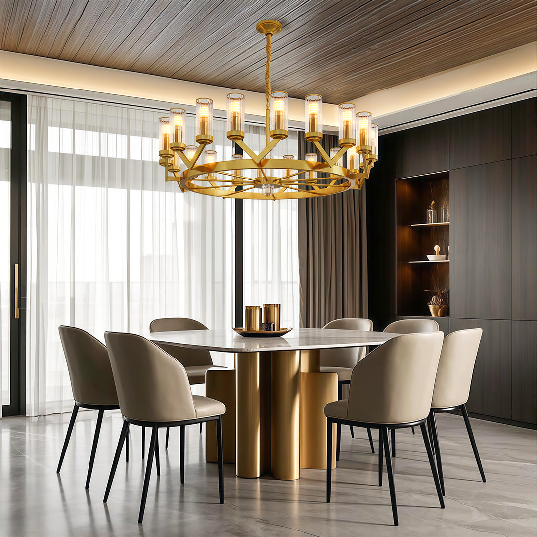 Glass drop chandelier illuminating modern dining space with brass table and designer chairs