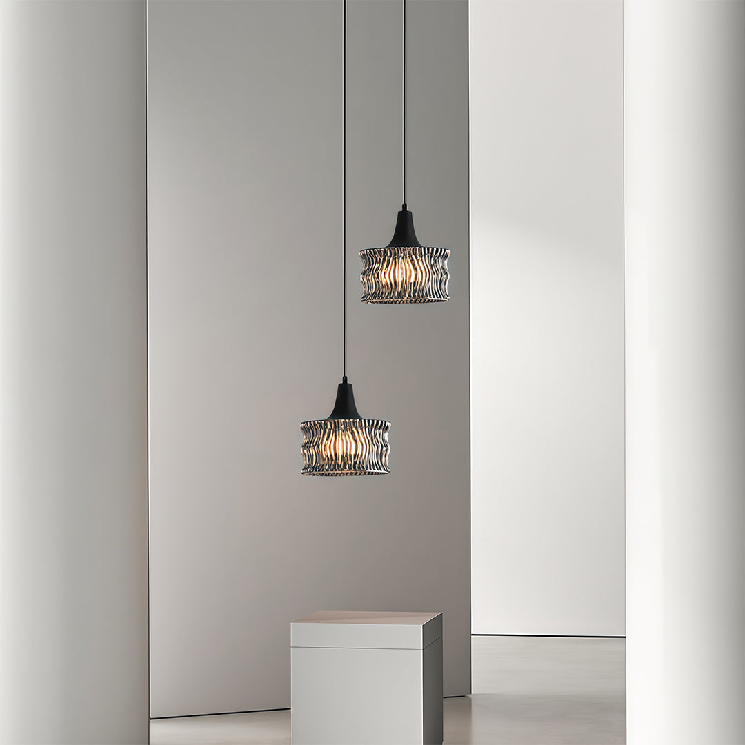 Glass drum pendant light hanging beside a bed, offering warm and ambient illumination.