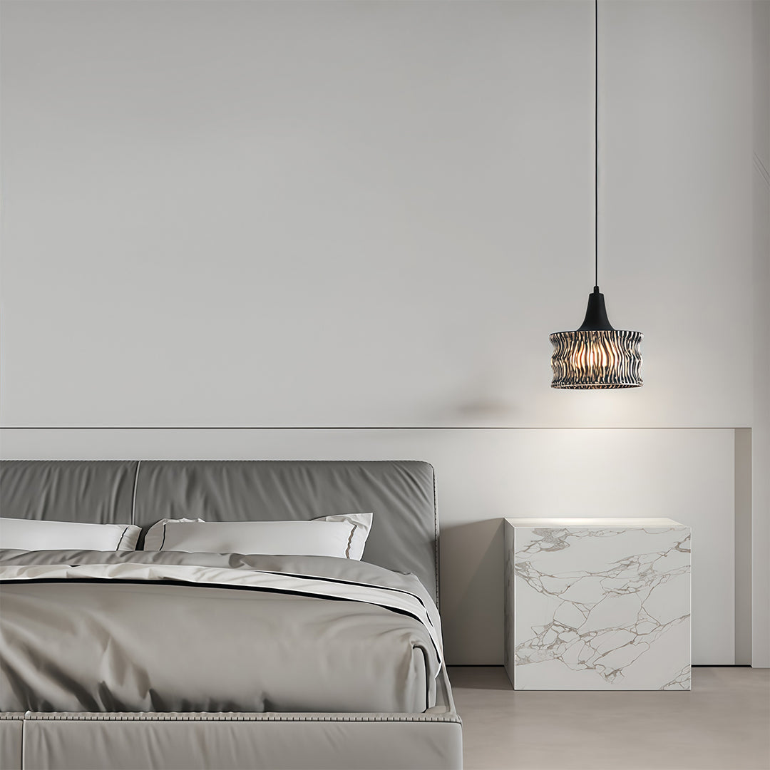 Glass drum pendant light above a bed in a modern bedroom, enhancing the room's aesthetic.
