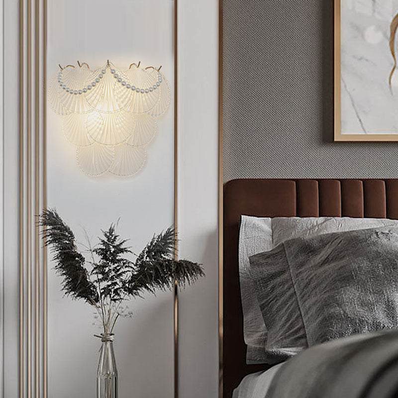 Glass feather wall light with a unique feather design casting a soft glow in a room.