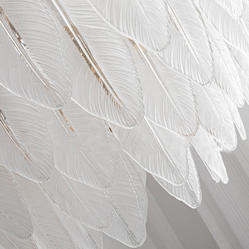 Glass feather wall light with a warm light, creating a cozy ambiance in a living space.