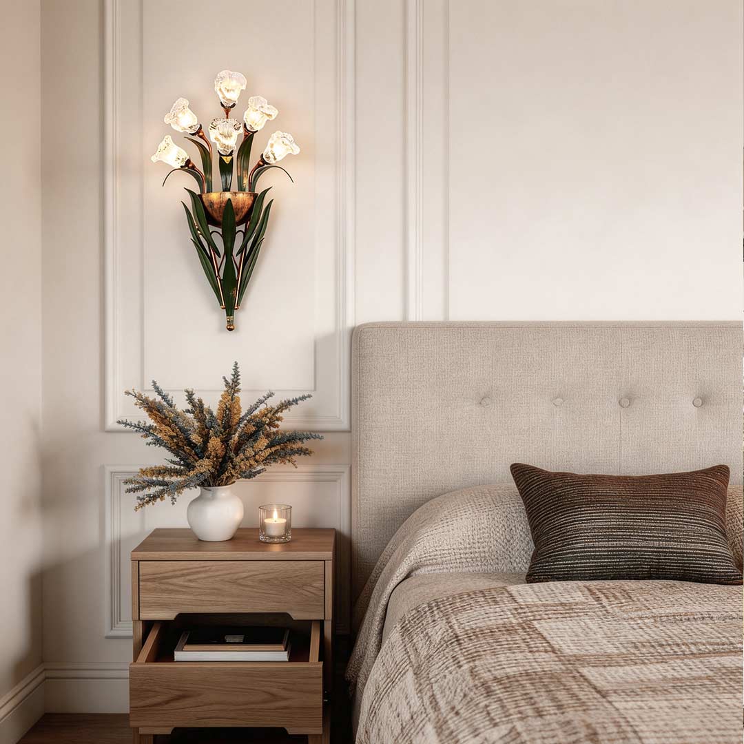 Glass flower sconce with pink flowers, mounted beside a modern bed in a cozy bedroom.