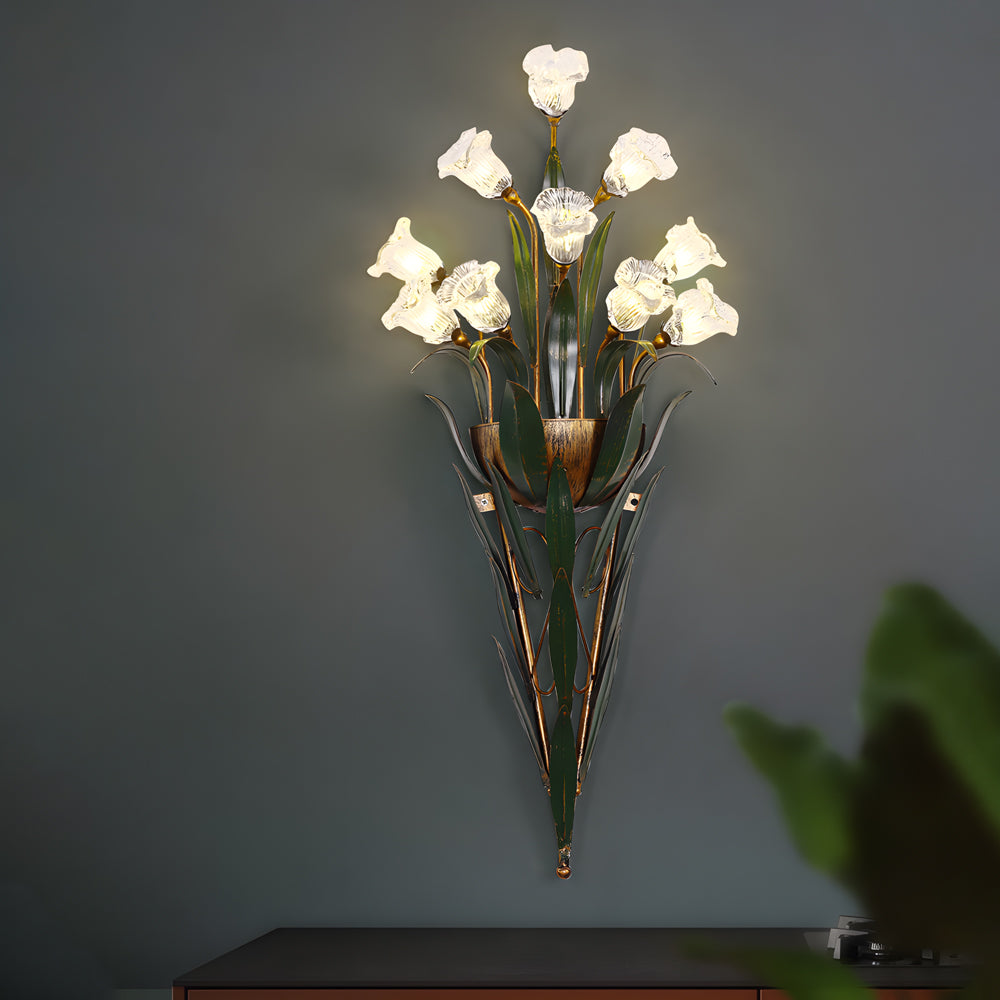 Glass flower sconce with white blooms, mounted on a dark wall for contrast.