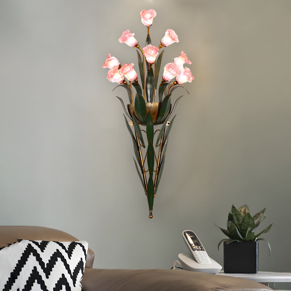 Glass flower sconce with white blooms, mounted beside a green accent wall.