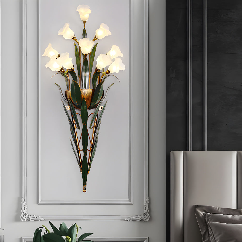Glass flower sconce with white flowers, providing warm illumination in a modern room.