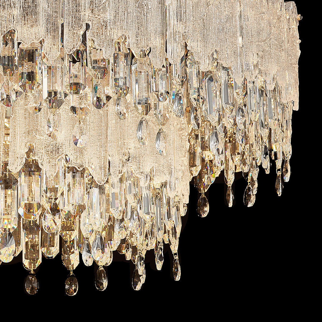 Detailed view of glass fringe chandeliers neck with gold mount and textured glass rod.