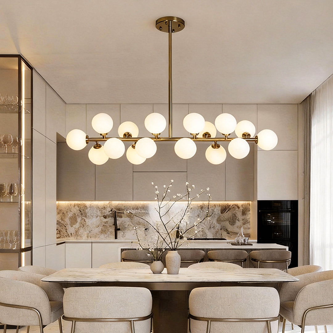 Glass globe linear chandelier illuminating a modern dining area with warm, ambient glow.