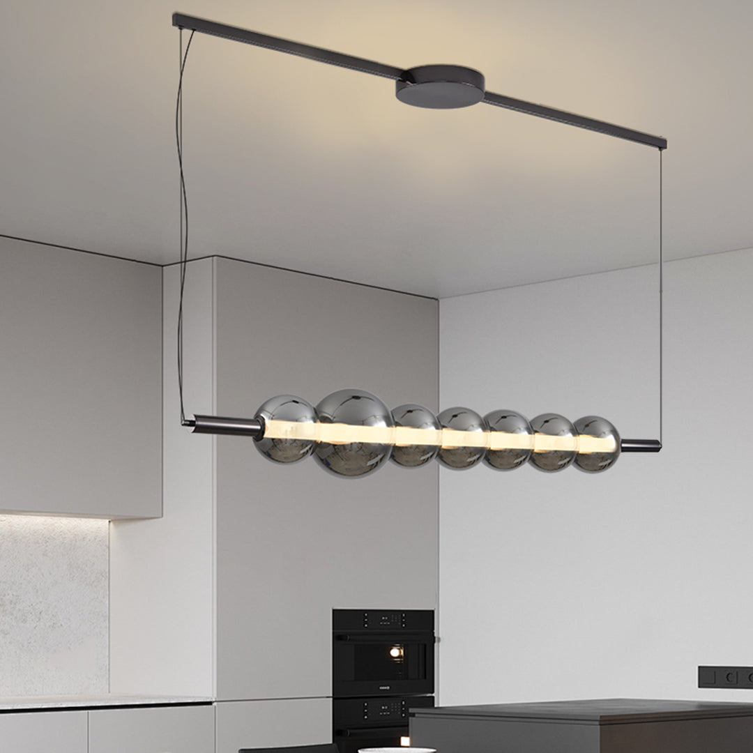 Contemporary silver pendant light for kitchen island with glass globe fixtures in sleek modern kitchen setting