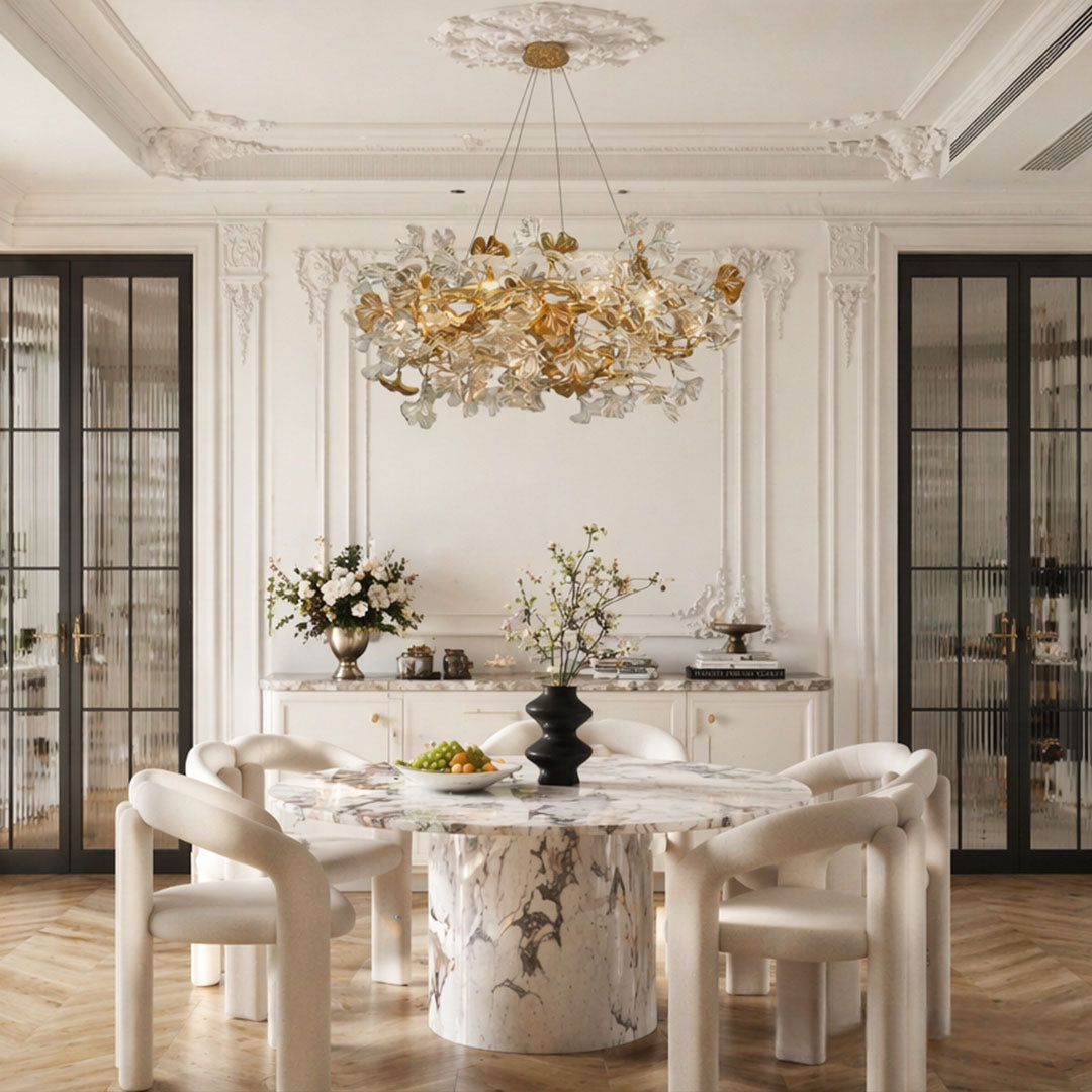 Glass leaf chandelier installed above a round dining table in a refined classic interior.