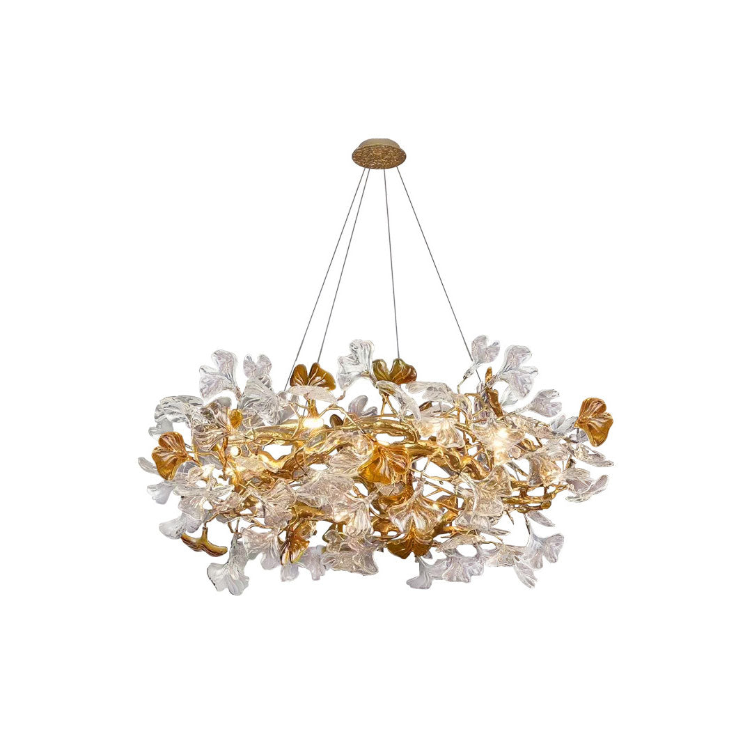 Glass leaf chandelier featuring layered clear and amber leaves with a sculptural gold frame.